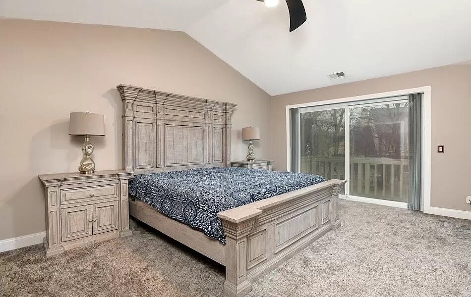 A Bedroom With A Bed And A Mirror In A Room