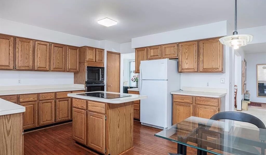 A Large Kitchen With Stainless Steel Appliances And Wooden Cabinets