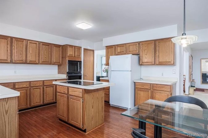 A Large Kitchen With Stainless Steel Appliances And Wooden Cabinets