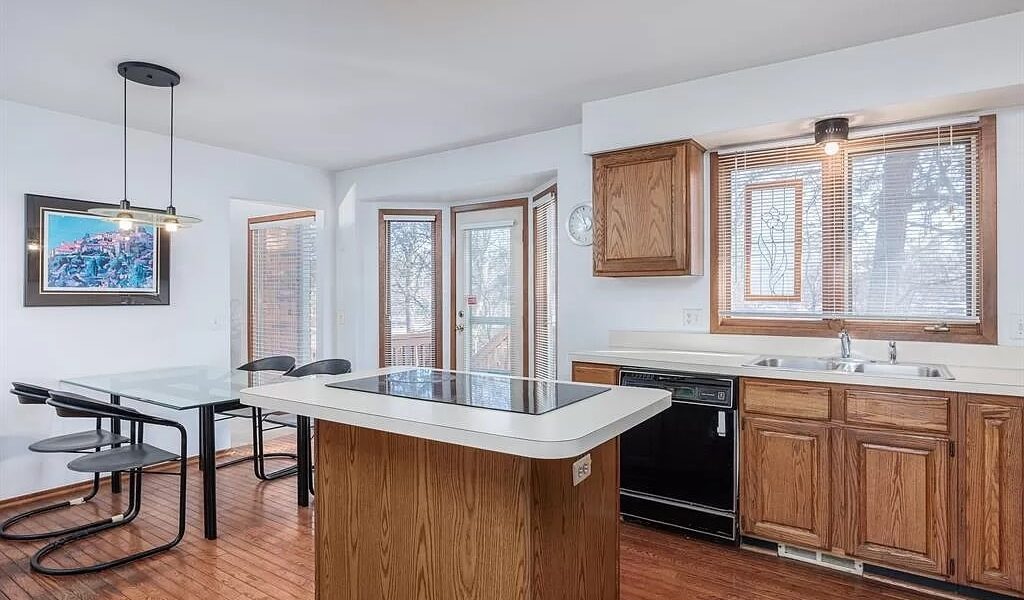 A Kitchen With Wooden Cabinets And A Wood Floor