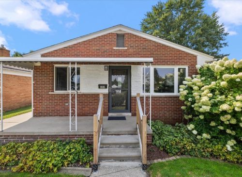 A House With Bushes In Front Of A Brick Building