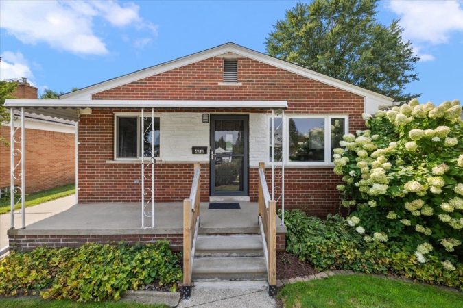 A House With Bushes In Front Of A Brick Building