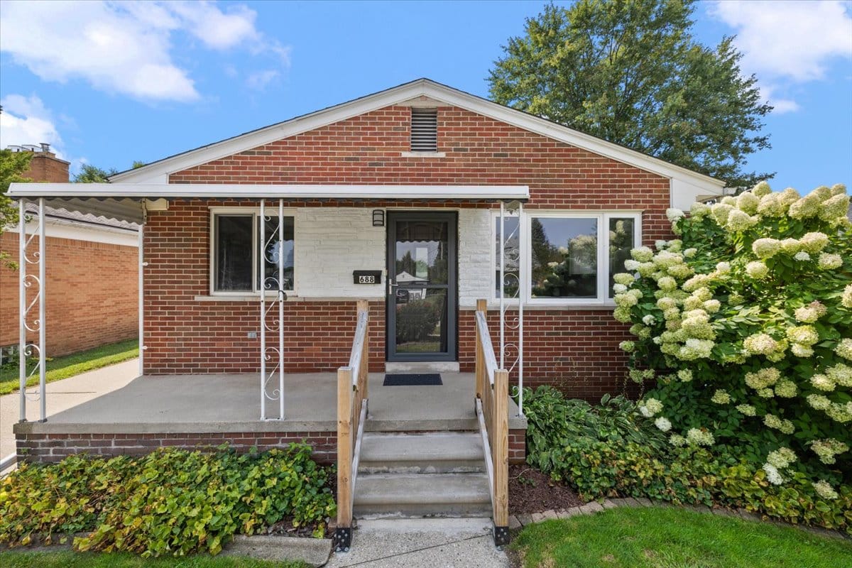 a house with bushes in front of a brick building