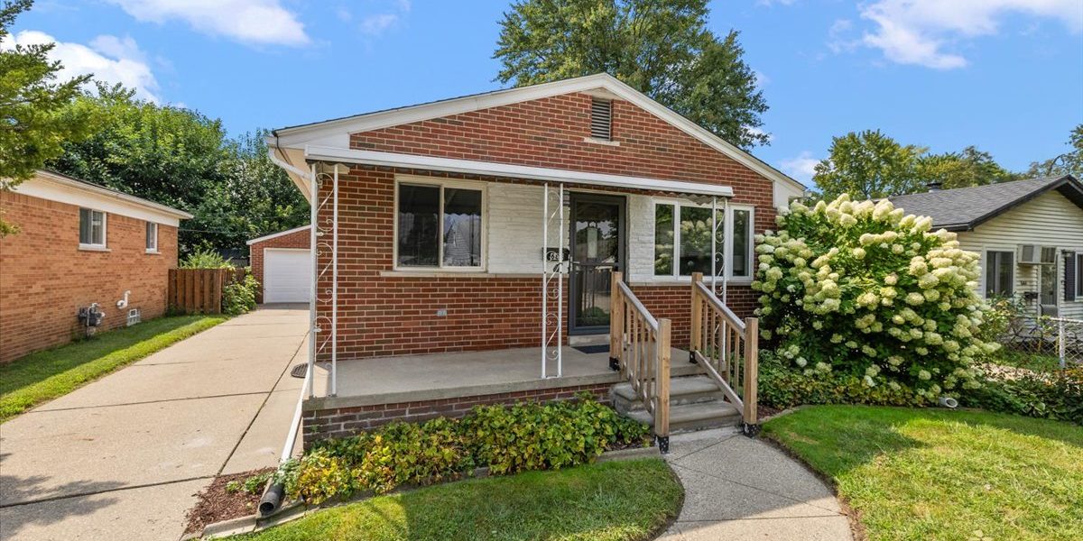 A House With A Lawn In Front Of A Brick Building