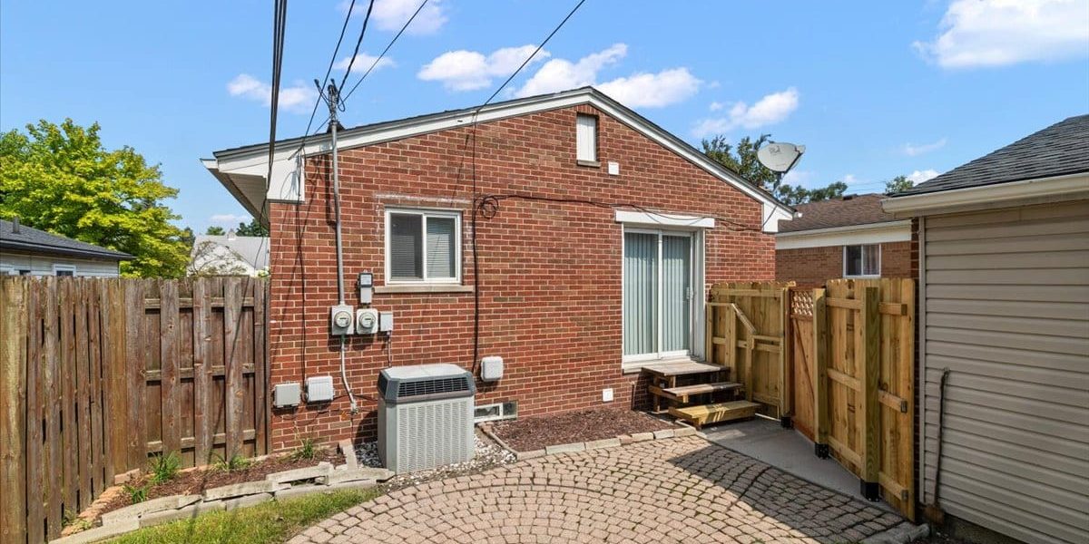 A Large Brick Building With A Wooden Fence