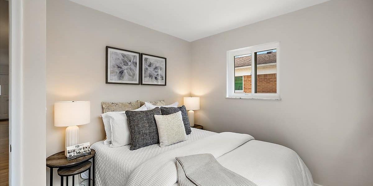 A Bedroom With A Bed And A Chair In A Room