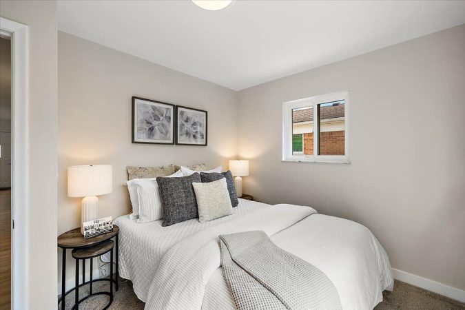 A Bedroom With A Bed And A Chair In A Room